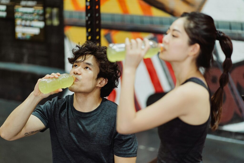 a couple in the gym drinking pre workout together